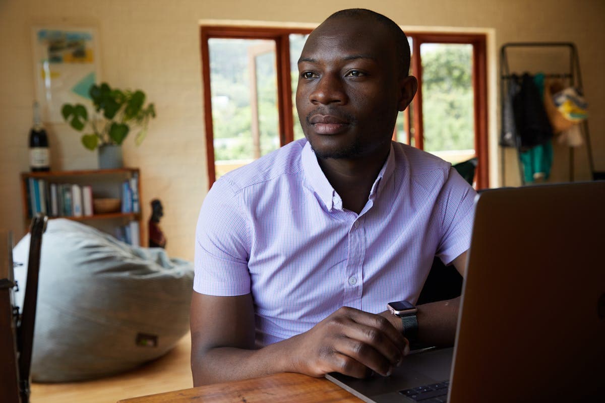 Un jeune Camerounais travaillant sur son ordinateur portable — gagner de l'argent en ligne au Cameroun