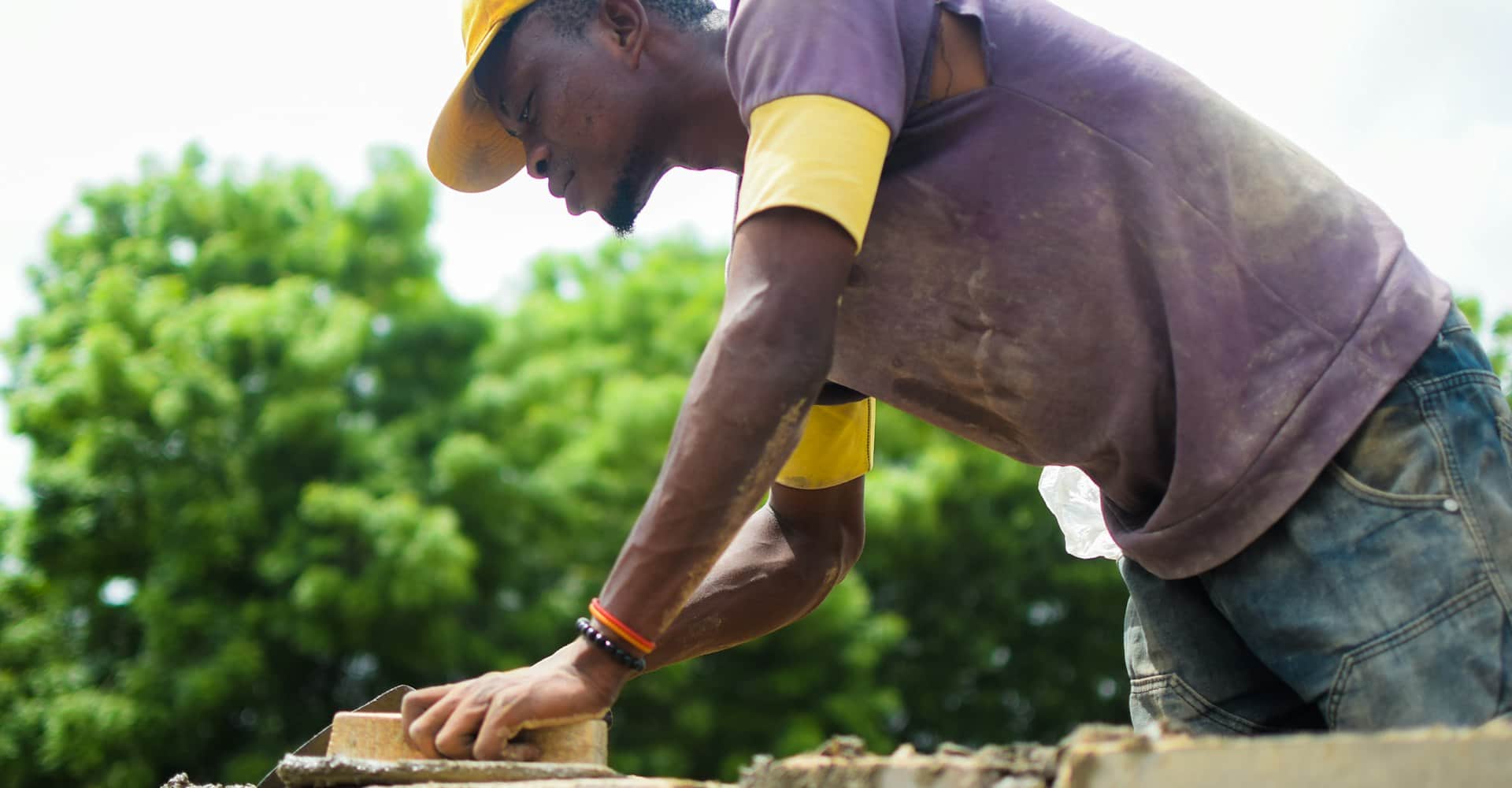 African worker laying bricks on a construction site